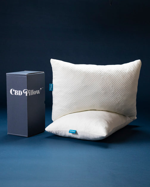 The CBD Pillow shown on a bed